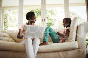 Mother and daughter using laptop and digital tablet