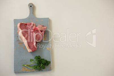 Sirloin chop on wooden board against white background