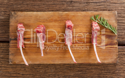 Rib chop and rosemary herb on on wooden tray against wooden background