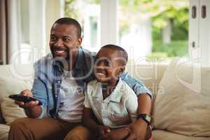 Son and father watching television