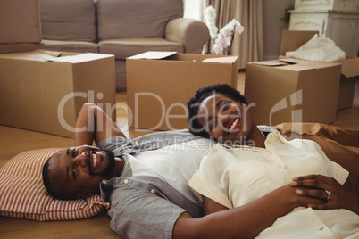 Portrait of smiling couple lying in living room