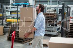 Factory worker carrying cardboard boxes in factory