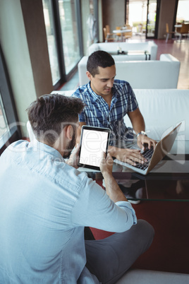 Executives using laptop and digital tablet in cafÃ?Â©