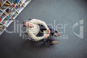 Overhead view of disabled school teacher holding book in library