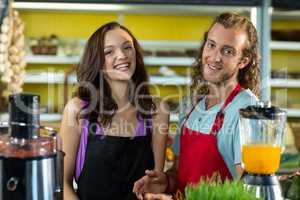 Smiling shop assistants standing together in health grocery shop