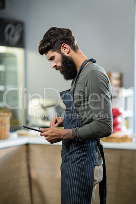 Salesman using digital tablet at counter