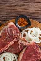 Blade chop, onions and spices on wooden round tray