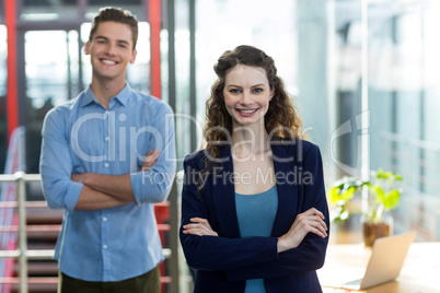 Business executives standing with arms crossed in office