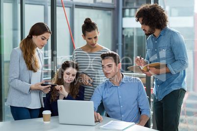 Business team discussing over laptop in meeting