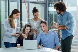 Business team discussing over laptop in meeting