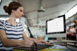 Graphic designer using graphic tablet and desktop