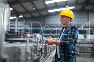 Factory worker monitoring production line