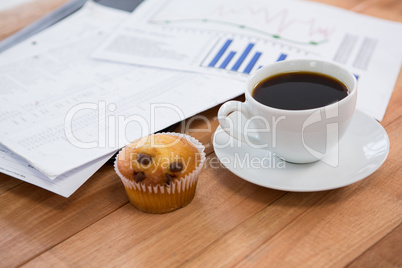 Coffee cup with graph document and cupcake