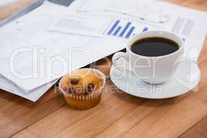 Coffee cup with graph document and cupcake
