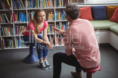 Teacher interacting with student in library