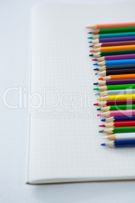 Colored pencils kept on the book