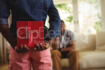 Son hiding gift behind his back for father