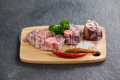 Sirloin chop, salt and chili on wooden board