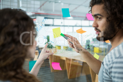 Executives discussing over sticky notes