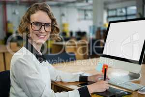 Confident woman sitting at desk in office