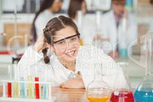 Portrait of smiling schoolgirl leaning on table in laboratory