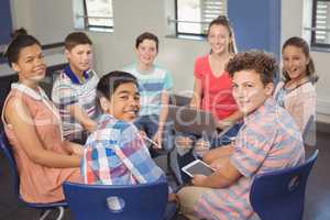 Portrait of students holding laptop, digital tablet