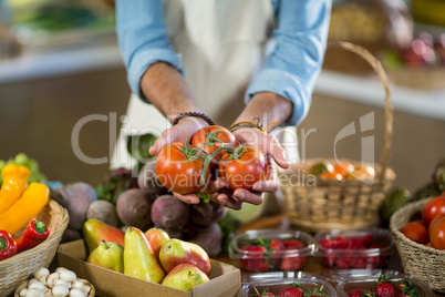 Vendor offering tomatoes at the counter