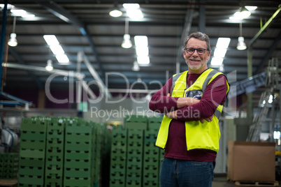 Portrait of male factory worker standing with arms crossed