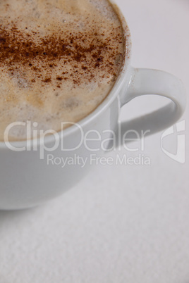 Close-up of white coffee cup with creamy froth