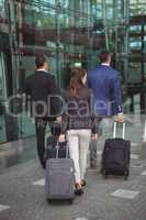 Business executives walking with suitcase outside platform
