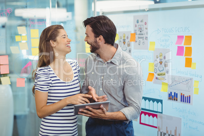 Male and female business executives using digital tablet