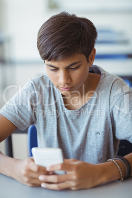 Schoolboy using mobile phone in classroom