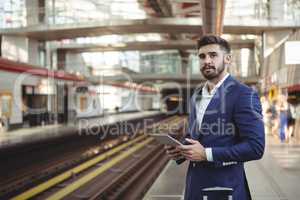 Executive using digital tablet on platform