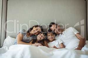 Parents and kids sitting on the bed