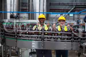 Factory workers showing their thumbs up at drinks production line