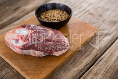 Sirloin chop and coriander seeds on wooden tray