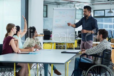 Business executives discussing over flip chart during meeting