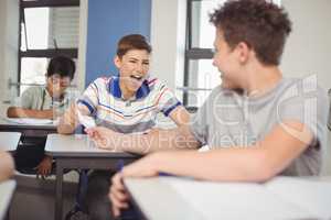 School students passing a chit in a secretive way inside the classroom