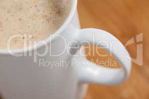Close-up of white mug of coffee with creamy froth