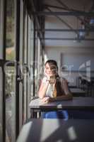 Thoughtful schoolgirl sitting in classroom