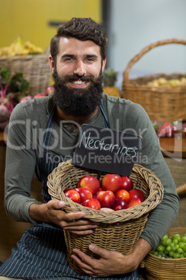 Smiling vendor holding a basket of nectarines