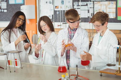 Attentive school kids doing a chemical experiment in laboratory