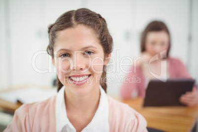 Smiling schoolgirl sitting in the classroom