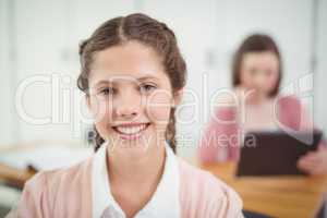 Smiling schoolgirl sitting in the classroom