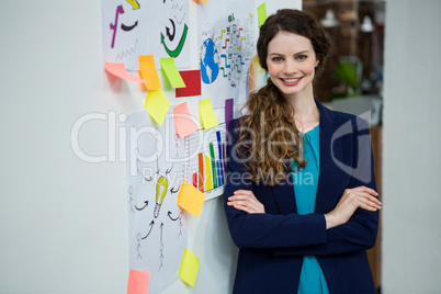 Beautiful woman standing by wall with adhesive notes