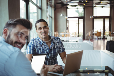 Executives using laptop and digital tablet in cafÃ?Â©