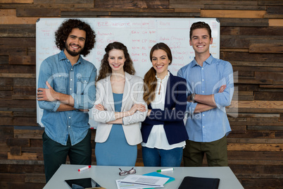 Portrait of smiling business executives standing with arms crossed