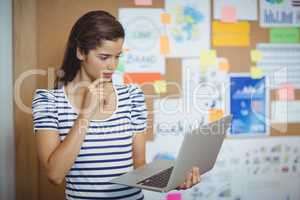 Female executive using laptop in office