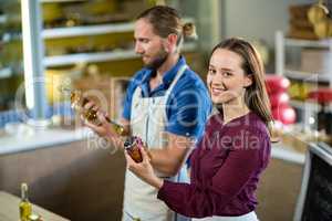 Shop assistants looking at olive oil and pickle bottles