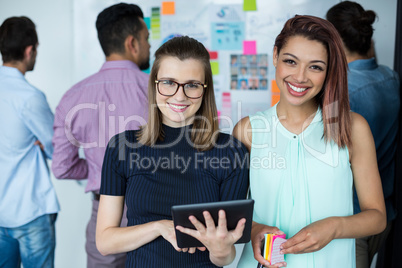 Business executives standing with digital tablet and coffee cup in office